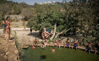Les gens profitent d'une chaude journée d'été à la source Ein Lavan dans les montagnes de Jérusalem, le 30 août 2020. (Yonatan Sindel/Flash90)