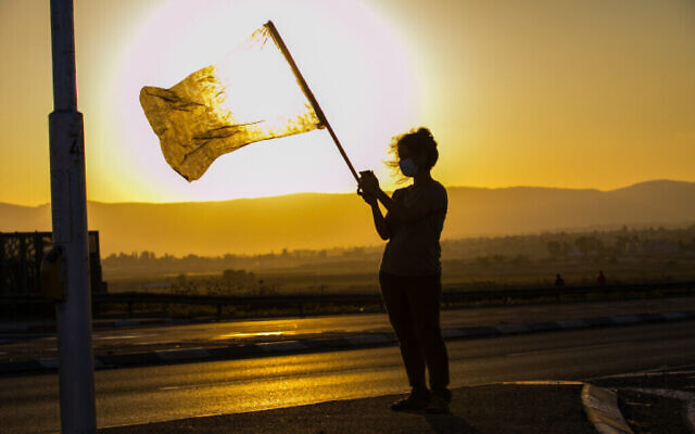 Une manifestante agite un drapeau dans la vallée de Jezreel, au nord d'Israël, le 26 septembre 2020. (Anat Hermony/Flash90)