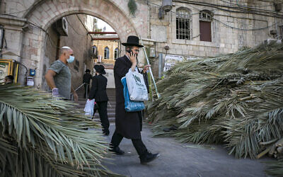 Des Juifs ultra-orthodoxes parmi des branches de palmier pour la prochaine fête de Souccot dans le quartier de Mea Sharim à Jérusalem, le 30 septembre 2020 (Crédit : Olivier Fitoussi/Flash90)