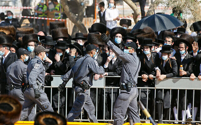 La police tente d'éloigner les Haredim venus participer aux funérailles du rabbin Mordechai Leifer, le "rabbin de Pittsburgh", à Ashdod, le 5 octobre 2020. (Crédit :Flash90) La police tente d'éloigner les Haredim venus participer aux funérailles du rabbin Mordechai Leifer, le "rabbin de Pittsburgh", à Ashdod, le 5 octobre 2020. (Crédit :Flash90)
