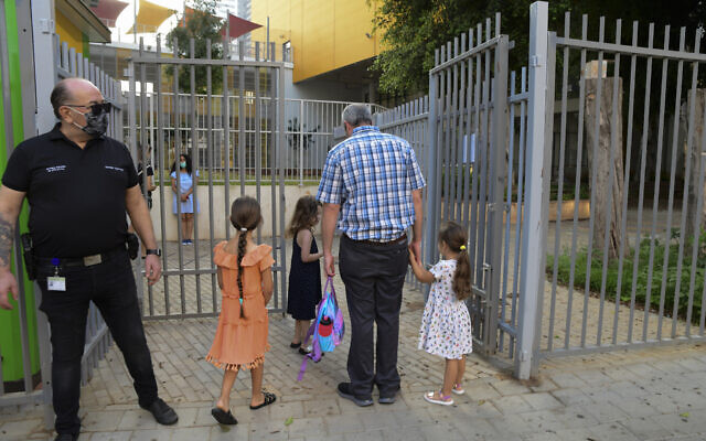 Des parents accompagnent leurs enfants au jardin d'enfants à Tel Aviv après l'allègement du confinement national pour cause de coronavirus, le 18 octobre 2020 (Crédit : Avshalom Sassoni/Flash90) Des parents accompagnent leurs enfants au jardin d'enfants à Tel Aviv après l'allègement du confinement national pour cause de coronavirus, le 18 octobre 2020 (Crédit : Avshalom Sassoni/Flash90)