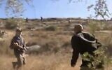 Un résident d'implantation armé d'un bâton (G) s'en prend au journaliste de la Douzième chaîne Ohad Hemo lors de heurts avec des cueilleurs d'olives palestiniens dans le village cisjordanien de Bourka, le 13 octobre 2020. (Capture écran/ Twitter)