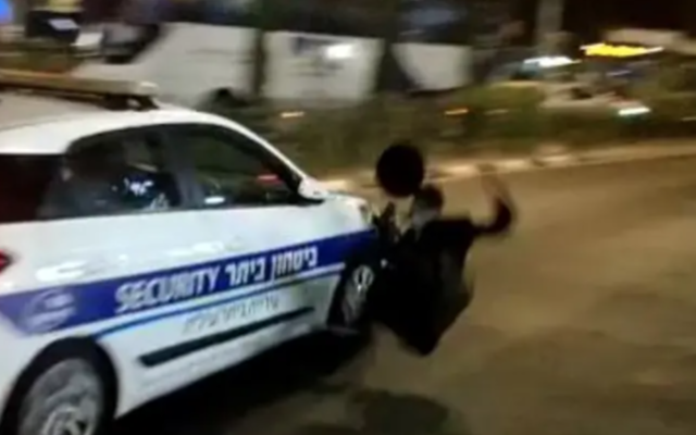 Une voiture de sécurité municipale s'éloigne en percutant un haredi qui manifestait contre le prolongement du confinement dans la ville de Beitar Illit, le 15 octobre 2020. (Capture d'écran /Twitter) Une voiture de sécurité municipale s'éloigne en percutant un haredi qui manifestait contre le prolongement du confinement dans la ville de Beitar Illit, le 15 octobre 2020. (Capture d'écran /Twitter)