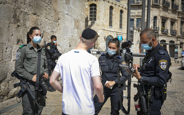 La police donne à un homme une amende pour avoir violé les règles nationales de confinement à la porte de Jaffa dans la vieille ville de Jérusalem le 24 septembre 2020. (Olivier Fitoussi/Flash90) La police donne à un homme une amende pour avoir violé les règles nationales de confinement à la porte de Jaffa dans la vieille ville de Jérusalem le 24 septembre 2020. (Olivier Fitoussi/Flash90)