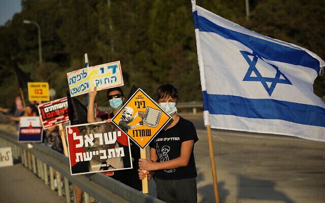 Des militants manifestent contre le Premier ministre Benjamin Netanyahu sur la route 3, dans le centre d'Israël, le 10 octobre 2020 (Nati Shohat/Flash90) Des militants manifestent contre le Premier ministre Benjamin Netanyahu sur la route 3, dans le centre d'Israël, le 10 octobre 2020 (Nati Shohat/Flash90)