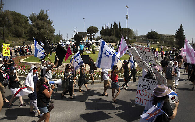 Des manifestants agitent des drapeaux et scandent des slogans lors d'une manifestation contre une mesure proposée pour réduire les manifestations publiques pendant le confinement national actuel en raison de la pandémie de coronavirus, devant la Knesset, à Jérusalem, le 29 septembre 2020. (Sebastian Scheiner/AP)