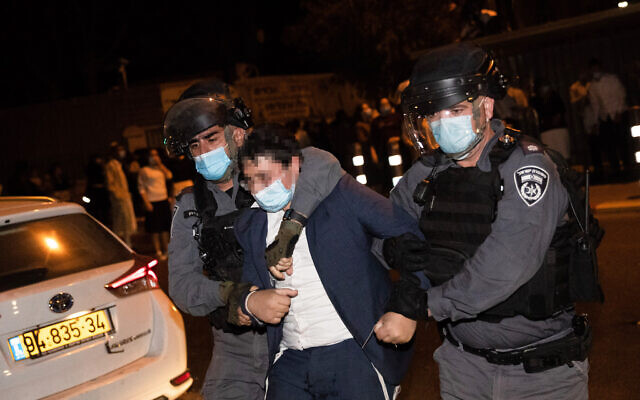 Des policiers arrêtent un manifestant lors d'un rassemblement contre l'application des règlements d'urgence dus au coronavirus, devant le quartier juif ultra-orthodoxe de Mea Shearim, à Jérusalem, le 5 octobre 2020. (Yonatan Sindel/Flash90) Des policiers arrêtent un manifestant lors d'un rassemblement contre l'application des règlements d'urgence dus au coronavirus, devant le quartier juif ultra-orthodoxe de Mea Shearim, à Jérusalem, le 5 octobre 2020. (Yonatan Sindel/Flash90)