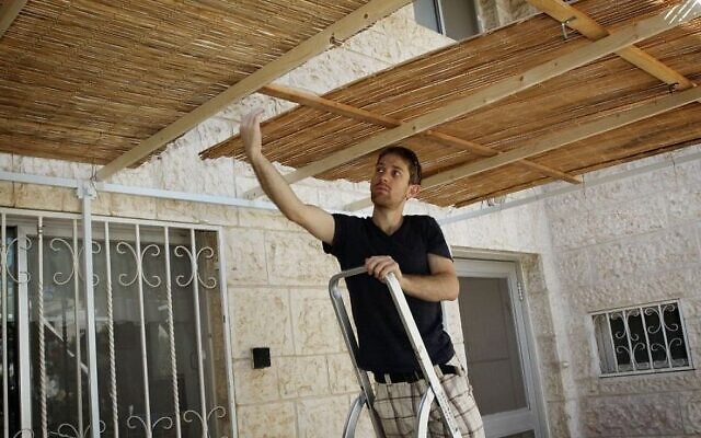 Photo illustrative d'un jeune homme construisant une soucca. (Gershon Elinson/Flash90)