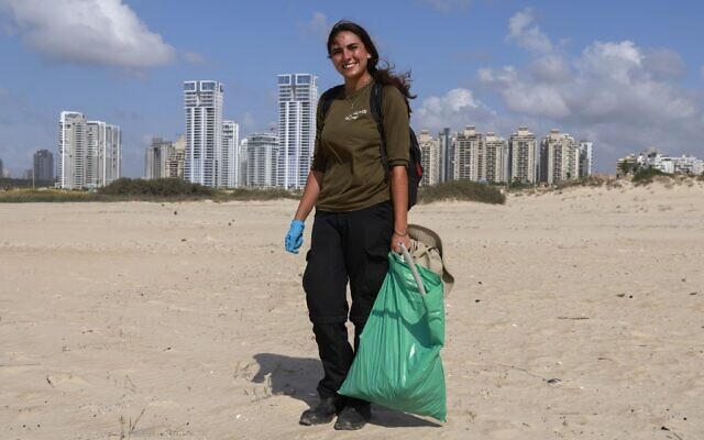 Lotem Benbenishti, 28 ans, a trouvé du travail dans la collecte de déchets sur la plage Poleg de Netanya, le 21 octobre 2020. (Crédit : MENAHEM KAHANA / AFP) Lotem Benbenishti, 28 ans, a trouvé du travail dans la collecte de déchets sur la plage Poleg de Netanya, le 21 octobre 2020. (Crédit : MENAHEM KAHANA / AFP)