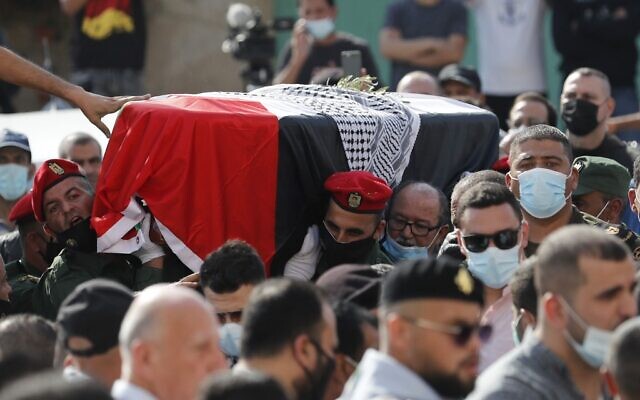 Des Palestiniens et des gardes d'honneur transportent le cercueil de Saeb Erekat pendant la procession de ses funérailles à Jéricho, en Cisjordanie, le 11 novembre 2020. (Crédit : Ahmad GHARABLI / PPO / AFP) Des Palestiniens et des gardes d'honneur transportent le cercueil de Saeb Erekat pendant la procession de ses funérailles à Jéricho, en Cisjordanie, le 11 novembre 2020. (Crédit : Ahmad GHARABLI / PPO / AFP)