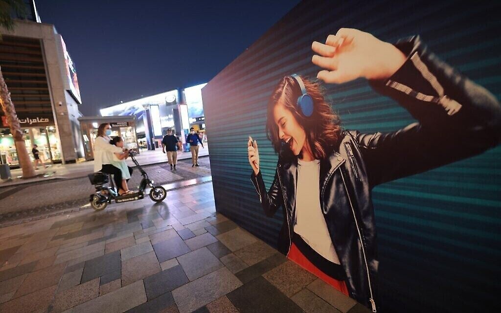 La photo d'une femme, portant des écouteurs et en train de danser, affichée sur un mur de la Jumeirah Beach Residence à Dubaï, le 16 novembre 2020. (Crédit : Giuseppe CACACE / AFP)