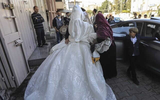 Une mariée palestinienne voilée quitte un salon de beauté dans le nord de la bande de Gaza le 13 novembre 2020, avant sa cérémonie de mariage au milieu de la pandémie de COVID-19. (Crédit : MAHMUD HAMS / AFP)