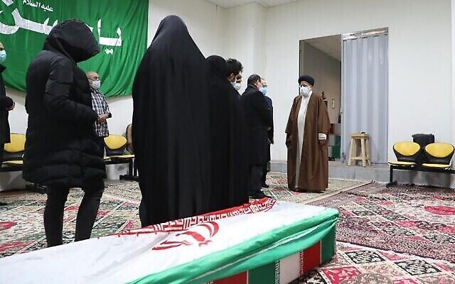 Le chef du pouvoir judiciaire, l'ayatollah Ebrahim Raisi (D), salue la dépouille du scientifique assassiné Mohsen Fakhrizadeh entourée de sa famille, à Téhéran le 28 novembre 2020. (Crédit : MIZAN NEWS AGENCY / AFP)
