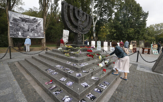 Une femme dépose des fleurs sur un monument près du ravin de Babi Yar où des dizaines de milliers de Juifs ont été tués pendant la Seconde Guerre mondiale, à Kiev, en Ukraine, le 29 septembre 2020. (Crédit : AP Photo/Efrem Lukatsky) Une femme dépose des fleurs sur un monument près du ravin de Babi Yar où des dizaines de milliers de Juifs ont été tués pendant la Seconde Guerre mondiale, à Kiev, en Ukraine, le 29 septembre 2020. (Crédit : AP Photo/Efrem Lukatsky)