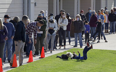 Des enfants jouent pendant que des électeurs font la queue pour déposer leur bulletin de vote au bâtiment du Waldens Ridge Emergency Services le jour du scrutin, le mardi 3 novembre 2020, à Walden, Tenn. (AP/Ben Margot)