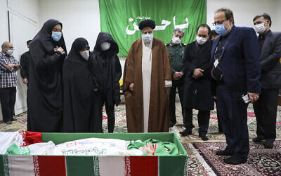 L'Ayatollah Ebrahim Raisi , responsable du système judiciaire iranien, rend hommage au scientifique assassiné Mohsen Fakhrizadeh en compagnie de sa famille à Téhéran, en Iran, le 28 novembre 2020. (Crédit : Agence de presse Mizan via AP)
