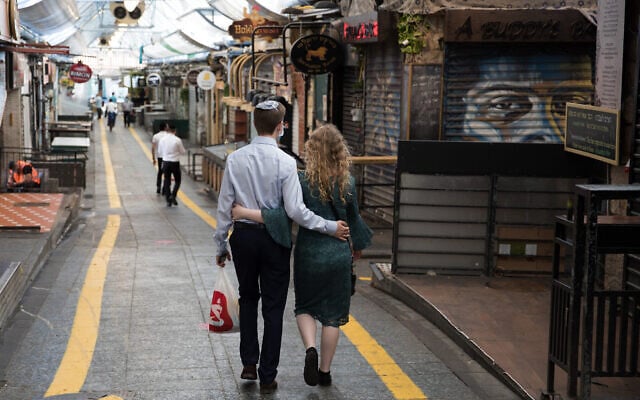 Photo d'illustration : Un couple marche à Jérusalem, au marché Mahane Yehuda, pendant le confinement entraîné par le coronavirus, le 25 septembre 2020. (Crédit : Nati Shohat/Flash90) Photo d'illustration : Un couple marche à Jérusalem, au marché Mahane Yehuda, pendant le confinement entraîné par le coronavirus, le 25 septembre 2020. (Crédit : Nati Shohat/Flash90)