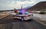 La police au bord d'une section inondée de l'Autoroute 90, dans le sud d'Israël, le 1er novembre 2020. (Crédit : Police israélienne)