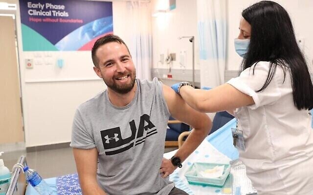 Hala Litwin, infirmière du centre médical de Sheba, injecte un vaccin expérimental contre le coronavirus au premier sujet humain testé en Israël, Segev Harel, le 1er novembre 2020. (Crédit :Ministère de la Défense) Hala Litwin, infirmière du centre médical de Sheba, injecte un vaccin expérimental contre le coronavirus au premier sujet humain testé en Israël, Segev Harel, le 1er novembre 2020. (Crédit :Ministère de la Défense)