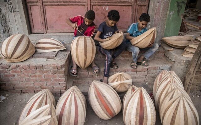 Des enfants travaillent sur des ouds en arabe dans un atelier appartenant à Khaled Azzouz, un oudiste chevronné, dans le quartier d'al-Marg, à la périphérie du Caire, la capitale égyptienne, le 26 octobre 2020. (Crédit : Khaled DESOUKI / AFP)
