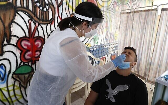 Une employée du centre médical Sheba utilise un écouvillon pour prélever un échantillon sur un étudiant pour un test de coronavirus au lycée hébraïque Herzliya à Tel Aviv, le 8 novembre 2020. (Jack Guez/ AFP) Une employée du centre médical Sheba utilise un écouvillon pour prélever un échantillon sur un étudiant pour un test de coronavirus au lycée hébraïque Herzliya à Tel Aviv, le 8 novembre 2020. (Jack Guez/ AFP)