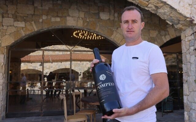 Le vigneron israélien Yaakov Berg tient une bouteille de son assemblage rouge nommé d'après le secrétaire d'État américain Mike Pompeo à la cave à vin de Psagot dans le parc industriel de Shaar Binyamin près de l'implantation israélienne de Psagot en Cisjordanie, au nord de Jérusalem, le 18 novembre 2020. (Emmanuel DUNAND / AFP)