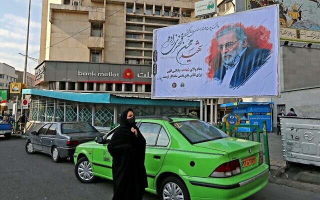 Une femme passant devant un panneau en hommage au scientifique nucléaire Mohsen Fakhrizadeh, à Téhéran, en Iran, le 30 novembre 2020. (Crédit : Atta Kenare/AFP) Une femme passant devant un panneau en hommage au scientifique nucléaire Mohsen Fakhrizadeh, à Téhéran, en Iran, le 30 novembre 2020. (Crédit : Atta Kenare/AFP)