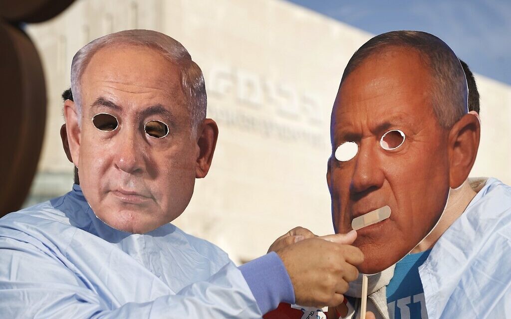 Des Israéliens portant les masques du Premier ministre Benjamin Netanyahu, à gauche, et du ministre de la Défense Benny Gantz lors d'une manifestation à Tel Aviv, le 2 décembre 2020. (Crédit : Jack Guez/AFP) Des Israéliens portant les masques du Premier ministre Benjamin Netanyahu, à gauche, et du ministre de la Défense Benny Gantz lors d'une manifestation à Tel Aviv, le 2 décembre 2020. (Crédit : Jack Guez/AFP)