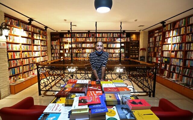 Un employé iranien pose pour une photo dans une librairie de la rue Enqelab (Révolution) à Téhéran, le 8 septembre 2020. (Crédit : ATTA KENARE / AFP)
