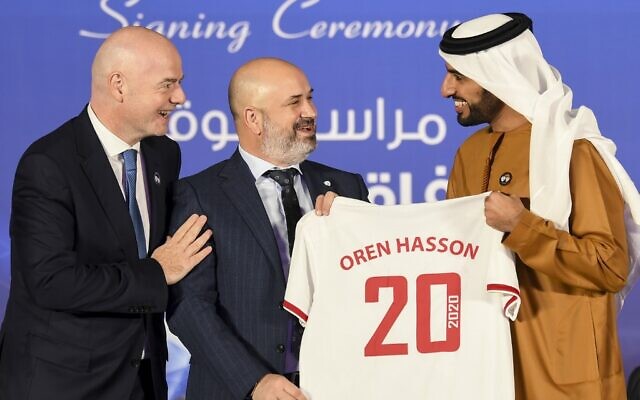 Le président de la FIFA Gianni Infantino (à gauche) avec le président de la Fédération israélienne de football Oren Hasson (au centre), qui reçoit un maillot du président de la Fédération des EAU (UAEFA) Sheikh Rashid Bin Humaid al-Nuaimi après la signature d'un protocole d'accord entre les deux associations à Dubaï, le 14 décembre 2020. (Crédit : Karim SAHIB / AFP) Le président de la FIFA Gianni Infantino (à gauche) avec le président de la Fédération israélienne de football Oren Hasson (au centre), qui reçoit un maillot du président de la Fédération des EAU (UAEFA) Sheikh Rashid Bin Humaid al-Nuaimi après la signature d'un protocole d'accord entre les deux associations à Dubaï, le 14 décembre 2020. (Crédit : Karim SAHIB / AFP)