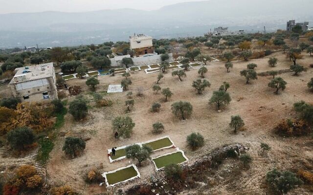 L'agriculteur syrien Ayman Ibrahim récoltant des fougères aquatiques Azolla utilisées comme aliments pour le bétail dans la ville de Kafr Takharim, dans la province d'Idleb, au nord-ouest de la Syrie, le 11 décembre 2020. (Crédit : AAREF WATAD / AFP) L'agriculteur syrien Ayman Ibrahim récoltant des fougères aquatiques Azolla utilisées comme aliments pour le bétail dans la ville de Kafr Takharim, dans la province d'Idleb, au nord-ouest de la Syrie, le 11 décembre 2020. (Crédit : AAREF WATAD / AFP)
