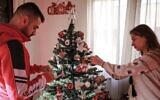 Saad Polus Qiryaqoz, un réfugié chrétien de 56 ans de la ville de Bartella, dans la plaine de Ninive au nord de l'Irak, décore un arbre de Noël dans sa nouvelle maison à Amman, la capitale jordanienne, le 18 décembre 2020. (Crédit : Khalil MAZRAAWI / AFP)