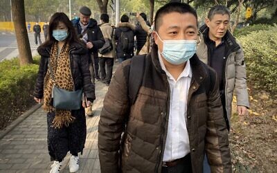 L'avocat Ren Quanniu (au centre), qui représente la journaliste citoyenne chinoise Zhang Zhan, qui a rendu compte de l'épidémie de COVID-19 à Wuhan et a été placée en détention depuis mai, arrive au tribunal populaire de Pudong à Shanghai où Zhang doit être jugé, le 28 décembre 2020. (Leo RAMIREZ / AFP)
