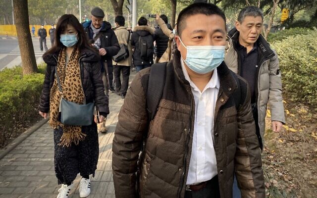 L'avocat Ren Quanniu (au centre), qui représente la journaliste citoyenne chinoise Zhang Zhan, qui a rendu compte de l'épidémie de COVID-19 à Wuhan et a été placée en détention depuis mai, arrive au tribunal populaire de Pudong à Shanghai où Zhang doit être jugé, le 28 décembre 2020. (Leo RAMIREZ / AFP)