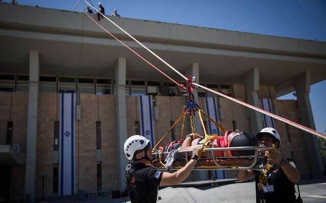 Des membres de la garde d'honneur de la Knesset, du Commandement du Front intérieur, des pompiers, de l’armée, de la police israélienne et du service de secours du Magen David Adom participant à un exercice d'urgence simulant un tremblement de terre à la Knesset, à Jérusalem, le 13 juin 2017. (Crédit : Hadas Parush/Flash90) Des membres de la garde d'honneur de la Knesset, du Commandement du Front intérieur, des pompiers, de l’armée, de la police israélienne et du service de secours du Magen David Adom participant à un exercice d'urgence simulant un tremblement de terre à la Knesset, à Jérusalem, le 13 juin 2017. (Crédit : Hadas Parush/Flash90)