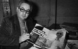 Le célèbre chasseur de nazis Serge Klarsfeld montre le numéro du magazine allemand « Bunte » qui présente un article et des photos sur le criminel de guerre nazi Alois Brunner, lors d'une conférence de presse à Paris, le 31 octobre 1985. (Crédit : AP / Michel Lipchitz)
