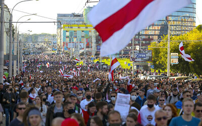 Des manifestants brandissent le vieux drapeau national biélorusse pendant un rassemblement de l'opposition pour protester contre les résultats officiels des élections présidentielles à Minsk, en Biélorussie, le 20 septembre 2020. (Crédit :  AP Photo/TUT.by)