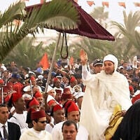 Le roi du Maroc Mohammed VI, à cheval, saluant à la sortie de la mosquée Moulay Abdelaziz de Laayaoune, au Sahara occidental, le 2 novembre 2001, dans le cadre de sa visite historique dans cette région désertique longtemps contestée. (Crédit : Jalil Bounhar/AP)