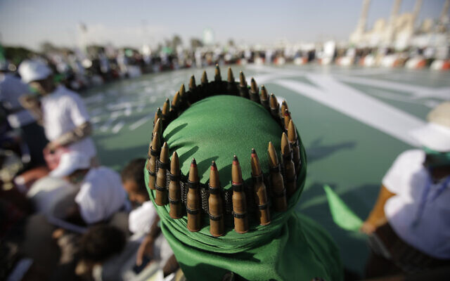 Un partisan des chiites Houthis, avec une ceinture de munitions placée sur sa tête, assiste à une célébration à Sanaa, au Yémen, le 9 novembre 2019. (Crédit : Hani Mohammed/AP) Un partisan des chiites Houthis, avec une ceinture de munitions placée sur sa tête, assiste à une célébration à Sanaa, au Yémen, le 9 novembre 2019. (Crédit : Hani Mohammed/AP)