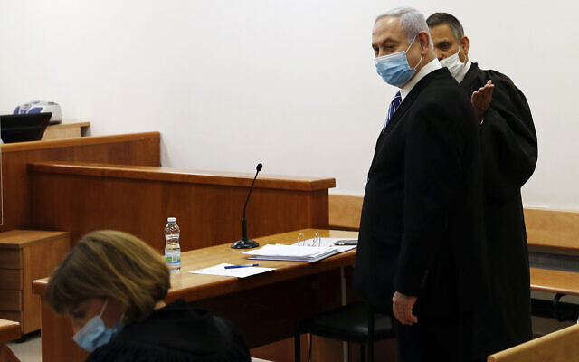 Le Premier ministre Benjamin Netanyahu, portant le masque dans le cadre de la pandémie de coronavirus, dans la salle d'audience où se déroule son procès pour corruption devant la cour de district de Jérusalem, le 24 mai 2020. (Crédit : Ronen Zvulun/ Pool Photo via AP)