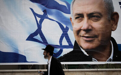Un juif orthodoxe marche près d'une affiche de campagne électorale montrant Benjamin Netanyahu à Jérusalem, le 2 avril 2019. (Yonatan Sindel/Flash90)