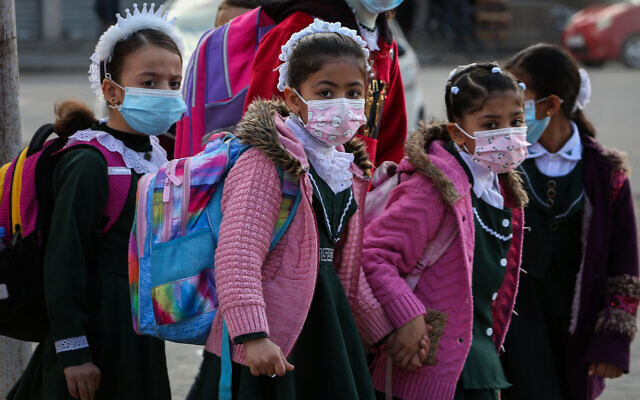 Des petites élèves palestiniennes affiliées à l'UNRWA des Nations unies portent le masque dans le cadre de la pandémie de coronavirus à Rafah, dans le sud de Gaza, le 25 novembre 2020. (Crédit : Abed Rahim Khatib/Flash90) Des petites élèves palestiniennes affiliées à l'UNRWA des Nations unies portent le masque dans le cadre de la pandémie de coronavirus à Rafah, dans le sud de Gaza, le 25 novembre 2020. (Crédit : Abed Rahim Khatib/Flash90)