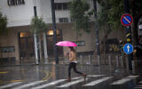 Une femme munie d'un parapluie par une journée pluvieuse d'hiver à Tel-Aviv, le 16 décembre 2020. (Crédit : Miriam Alster/Flash90)