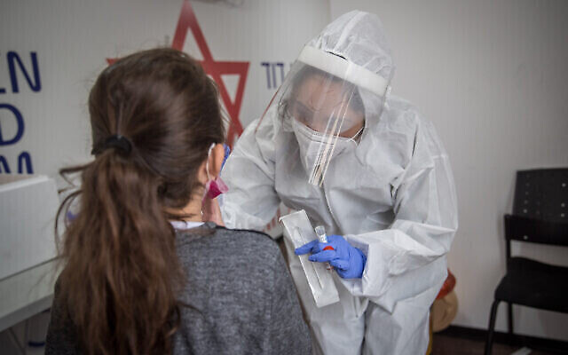 Un travailleur médical du Magen David Adom teste une Israélienne pour le coronavirus sur un site de tests mobile à Jérusalem le 16 décembre 2020. (Crédit : Yonatan Sindel / Flash90)