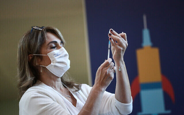 Une infirmière tient un vaccin contre la COVID-19 à l'hôpital Ichilov (Sourasky) de Tel Aviv, le 20 décembre 2020. (Crédit : Miriam Alster/Flash90) Une infirmière tient un vaccin contre la COVID-19 à l'hôpital Ichilov (Sourasky) de Tel Aviv, le 20 décembre 2020. (Crédit : Miriam Alster/Flash90)