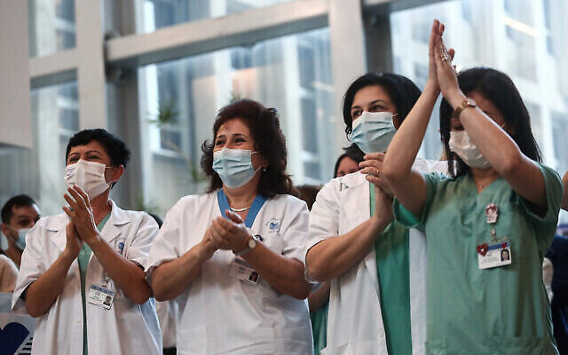 Des employées du secteur médical applaudissent au à l'hôpital Ichilov (Sourasky) de Tel Aviv, le 20 décembre 2020. (Crédit : Miriam Alster/Flash90) Des employées du secteur médical applaudissent au à l'hôpital Ichilov (Sourasky) de Tel Aviv, le 20 décembre 2020. (Crédit : Miriam Alster/Flash90)