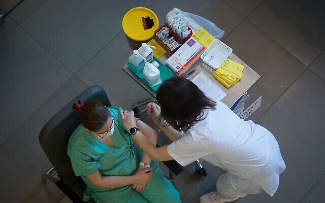 Personnel médical recevant un vaccin COVID-19 à l'hôpital Ichilov de Tel Aviv le 20 décembre 2020. (Crédit : Miriam Alster / Flash90) Personnel médical recevant un vaccin COVID-19 à l'hôpital Ichilov de Tel Aviv le 20 décembre 2020. (Crédit : Miriam Alster / Flash90)