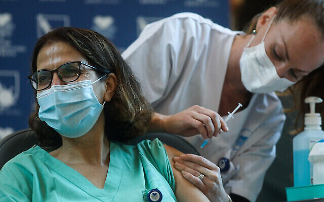 Une employés du secteur médical se fait vacciner contre la COVID-19 en Israël, à l'hôpital Ichilov (Sourasky) de Tel Aviv, le 20 décembre 2020. (Crédit : Miriam Alster/Flash90) Une employés du secteur médical se fait vacciner contre la COVID-19 en Israël, à l'hôpital Ichilov (Sourasky) de Tel Aviv, le 20 décembre 2020. (Crédit : Miriam Alster/Flash90)