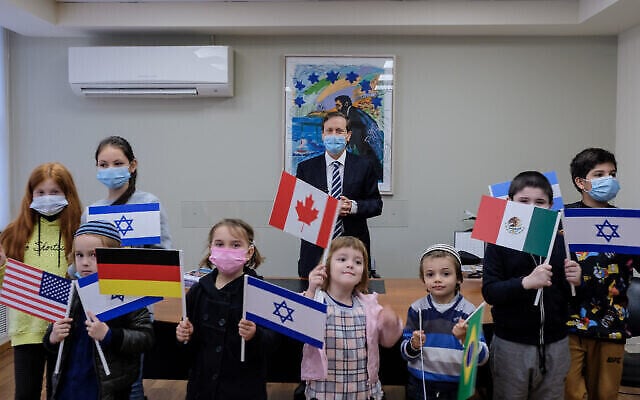 Le président de l'Agence juive Isaac Herzog, au centre, rencontre des enfants qui ont immigré en Israël pendant la pandémie de coronavirus, 28 décembre 2020. (David Salem / Agence juive pour Israël) Le président de l'Agence juive Isaac Herzog, au centre, rencontre des enfants qui ont immigré en Israël pendant la pandémie de coronavirus, 28 décembre 2020. (David Salem / Agence juive pour Israël)