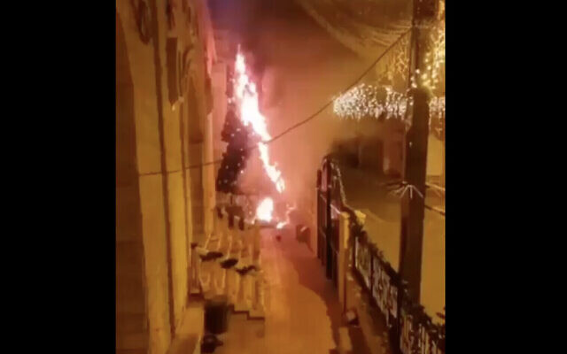 Une capture d'écran d'une vidéo publiée sur les réseaux sociaux montrant un arbre de Noël incendié devant une église dans la ville arabe israélienne de Sakhnin, le 30 décembre 2020. (Capture d'écran : Twitter) Une capture d'écran d'une vidéo publiée sur les réseaux sociaux montrant un arbre de Noël incendié devant une église dans la ville arabe israélienne de Sakhnin, le 30 décembre 2020. (Capture d'écran : Twitter)